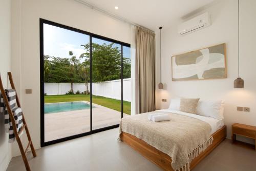 a bedroom with a bed and a view of a pool at Balear Villa in Kuta Lombok