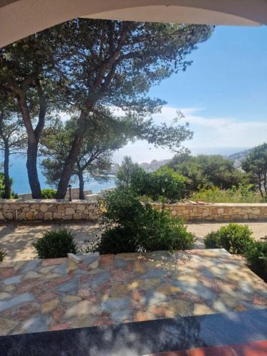 a view of a stone patio with trees and water at Villa Kristiano 21 in Sarandë