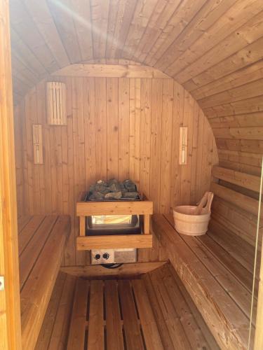 un petit sauna en bois avec un lavabo et un seau dans l'établissement Ferme Point du Jour avec sauna et jacuzzi, à Sainte-Marie-aux-Mines