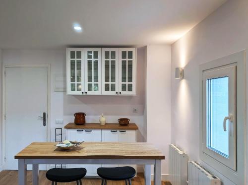 a kitchen with white cabinets and a table and chairs at Cal Moline 2 Estel in Aviá