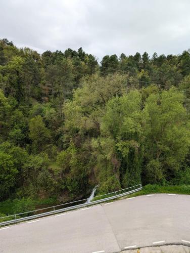 an empty road next to a hill with trees at Cal Moline 2 Estel in Aviá
