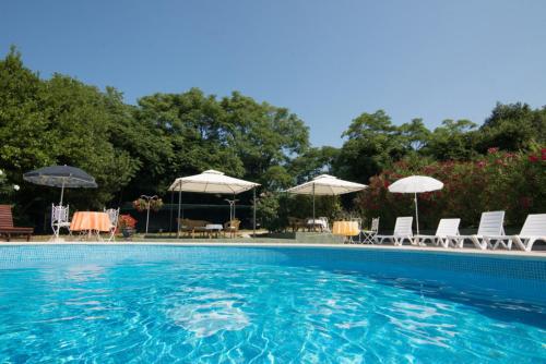 a swimming pool with chairs and umbrellas at Villa Anna in Savudrija