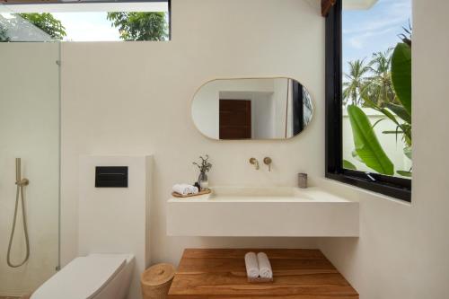 a bathroom with a white sink and a mirror at Balear Villa in Kuta Lombok