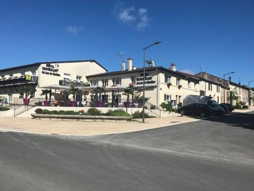 a parking lot in front of a white building at Hôtel SPA du Lac de Madine - Maison DRAPIER in Heudicourt-sous-les-Côtes
