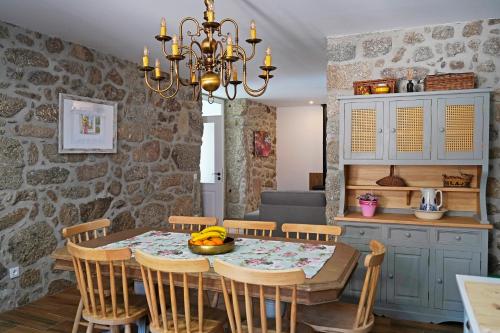 a kitchen and dining room with a table and chairs at A Casa de Sobrado - Countryside House in Barros