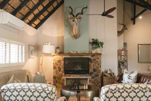 Una sala de estar con chimenea y televisión. en Buccara Waterberg - Molapo, en Lephalale