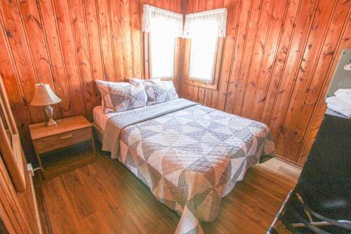 a bedroom with a bed in a wooden cabin at Sunnyside Combined 6BR 3BA Lakefront Retreat in Lincoln Junction