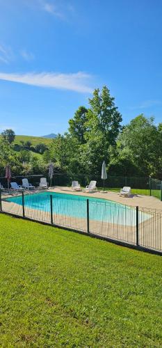 une clôture autour d'une piscine avec des chaises dans une cour dans l'établissement Pause nature à Souraïde au cœur du pays Basque, à Souraïde