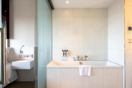 a bathroom with a sink and a bath tub at Pullman Eindhoven Cocagne in Eindhoven