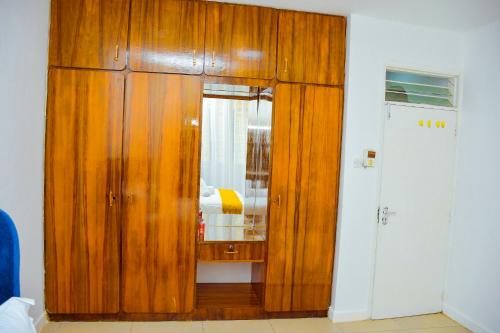 Armario de madera con espejo en una habitación en Modern, Spacious , Executive 1Bedroom Apartment, Milimani, Kisumu, Kenya, en Kisumu