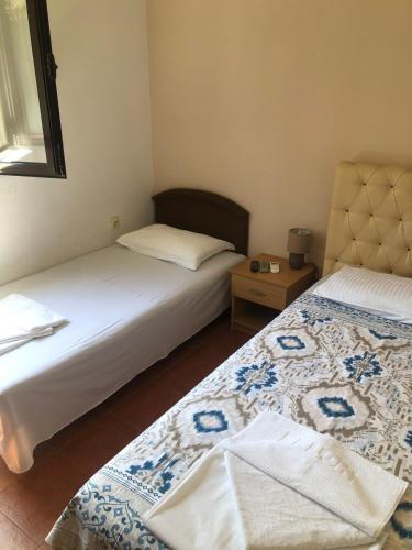 a bedroom with two beds and a table with a lamp at Apartmani Centar in Petrovac na Moru