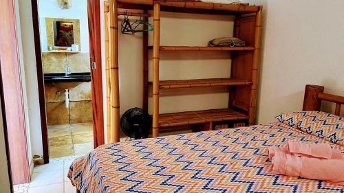 a bedroom with a bed and a book shelf at Ondas do mar Taiba Residence in Taíba