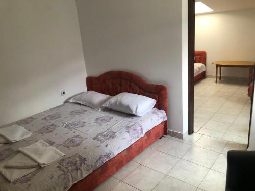 a bedroom with a bed with a red headboard at Apartmani Centar in Petrovac na Moru
