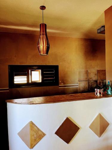 a kitchen with a counter and a pendant light at Ondas do mar Taiba Residence in Taíba