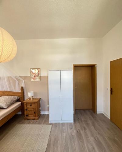 a bedroom with a white cabinet next to a bed at Direkt am Freizeitpark Plohn by Immo Franzi in Lengenfeld