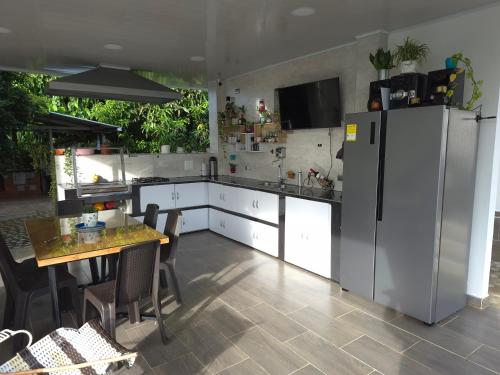 a kitchen with white cabinets and a table and a refrigerator at Villa Victoria Campestre in Rivera