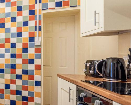 a kitchen with white cabinets and a stove top oven at Harbour place in Newcastle under Lyme with Parking, perfect for Contractors or Alton Towers in Stoke on Trent