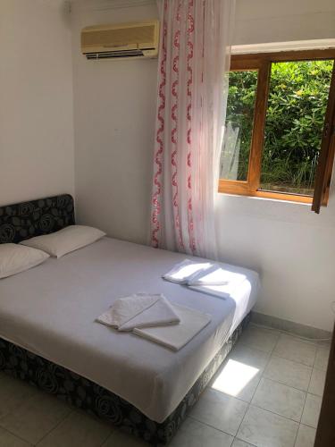 a small bedroom with a bed with a window at Apartmani Centar in Petrovac na Moru