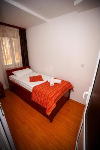 a small bedroom with a bed with a striped blanket at Ani Resort in Artavaz