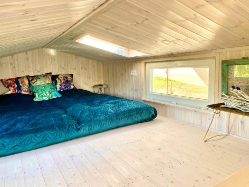a bedroom with a large blue bed in a room at Lavender Eco lodge át lake Balaton in Kisapáti