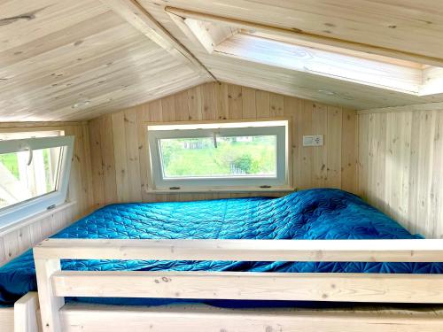 a bed in a cabin with a window at Lavender Eco lodge át lake Balaton in Kisapáti