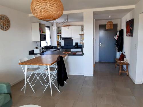 - une cuisine et un salon avec une table en bois dans la chambre dans l'établissement Porticcio grand appartement 3 pièces, 5 minutes de la plage, à Porticcio