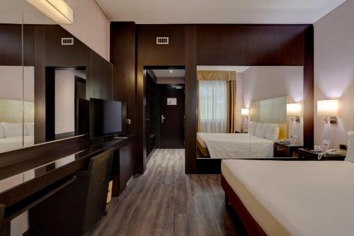 a hotel room with a bed and a large mirror at Hotel Nord in Guardamiglio