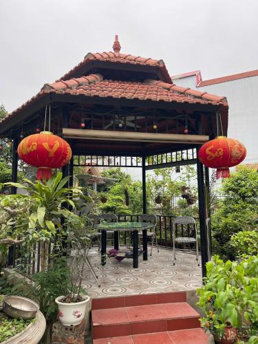 a gazebo with a picnic table in a garden at Tam Cốc ATHLECTIC BUNGALOW in Vũ Lâm