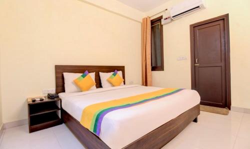 a bedroom with a large bed with colorful pillows at Hotel Royal Monarch in Gorakhpur