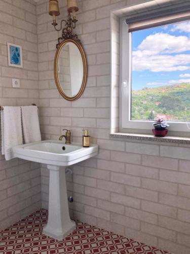 a white bathroom with a sink and a window at A Casa de Sobrado - Countryside House in Barros