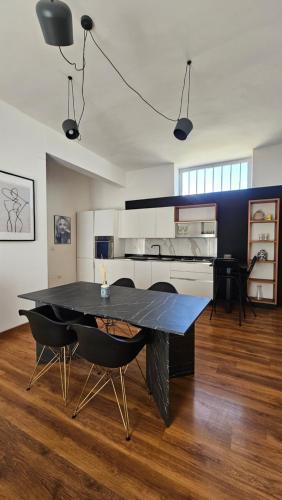 a dining room with a black table and chairs at Flamingo B&B in Pompei