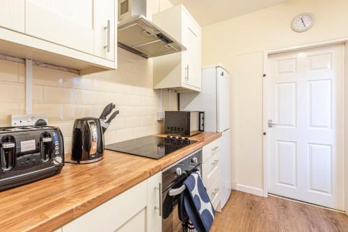 a kitchen with white cabinets and a counter top at Harbour place in Newcastle under Lyme with Parking, perfect for Contractors or Alton Towers in Stoke on Trent