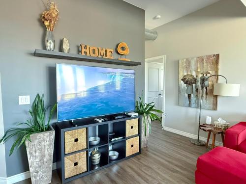 a living room with a flat screen tv on a entertainment center at Contemporary East Loft in Historic Niagara in Niagara on the Lake