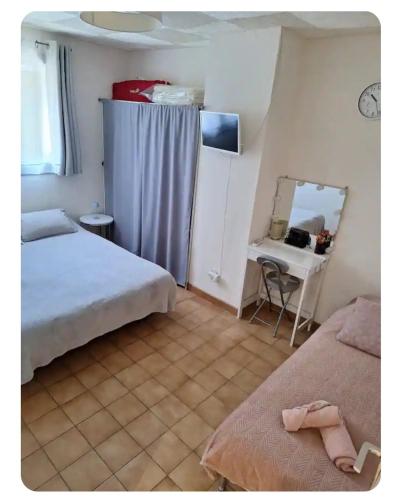 - une chambre avec 2 lits, un miroir et un bureau dans l'établissement Chambres au 1er étage d'une villa, à Ponteilla