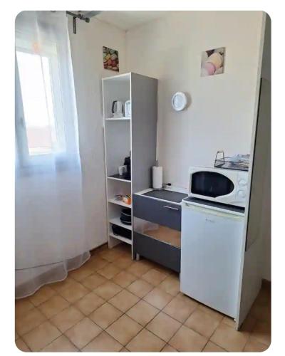 une petite cuisine avec un évier et une cuisinière dans l'établissement Chambres au 1er étage d'une villa, à Ponteilla