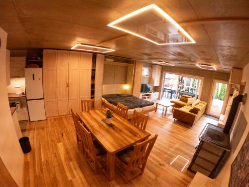 a living room with a wooden table and a kitchen at Apartmán U Holoubka in Nové Město na Moravě