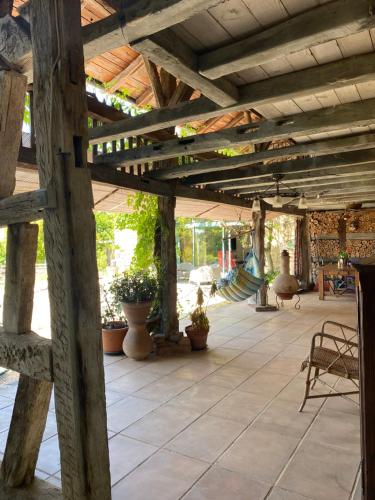 a large wooden patio with potted plants and hammocks at chambre d hôtes Ferme Bressane la barcarolle in Dommartin-lès-Cuiseaux