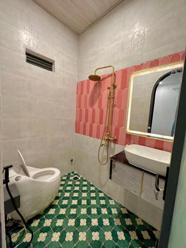 a bathroom with a toilet and a sink and a tub at Thalia Home Măng Đen in Kon Plong