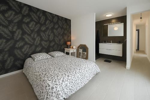 une chambre avec un grand lit et une salle de bain dans l'établissement Bel appartement proche des plages, à Anglet