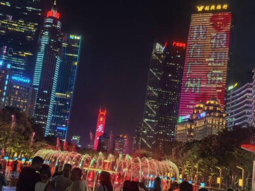 a group of people standing in front of a city at night at Guangzhou Yashe Hotel - Keyun Road Metro Station Pazhou Convention and Exhibition Store in Guangzhou