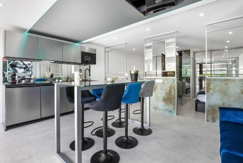 - une cuisine avec un comptoir et des tabourets dans l'établissement Village Naturiste R4N - La Villa Double Game Luxe, au Cap d'Agde