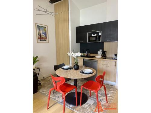 une cuisine avec une table et des chaises rouges dans une pièce dans l'établissement Appartement avec Terrasse privée sur les toits de Toulouse, à Toulouse