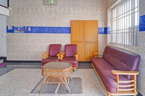 a waiting room with a couch and two chairs at Hotel O Royal Residency in Nāmakkal