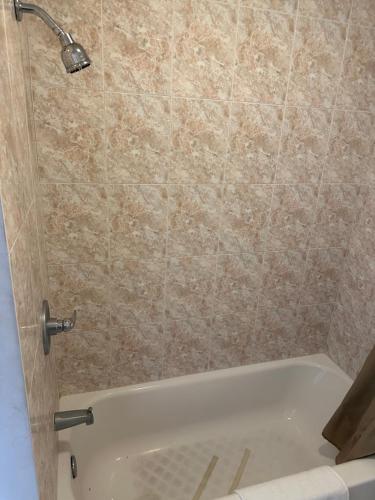 a bathroom with a shower with a bath tub at Palm Inn Motel - Rosemead, Los Angeles in Rosemead