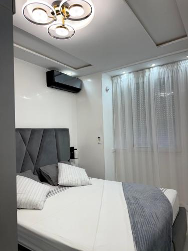 a bedroom with a large white bed with a ceiling fan at Jardins Anass 2 Aéroport Marrakech in Marrakech
