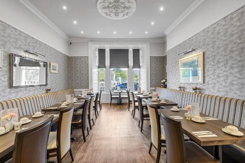 a dining room with wooden tables and chairs at Invicta Hotel Plymouth in Plymouth