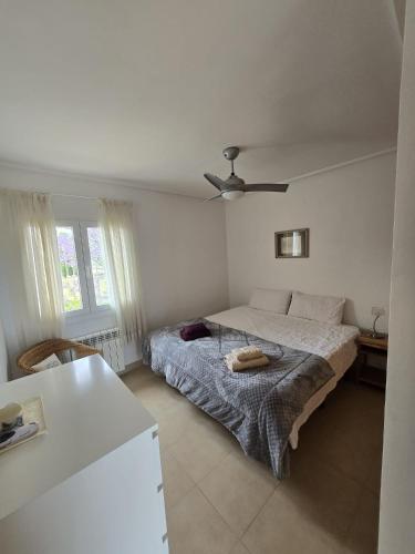 a bedroom with a bed and a ceiling fan at Mar Menor Golf Resort , La maison bleue, villa piscine privée in Los Martínez