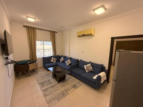 塞拉莱أجنحة هومينج ــ Homing Suites的客厅里有一张蓝色沙发和一台电视