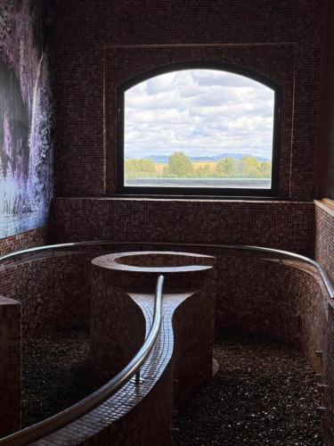 a bathroom with a window and a bath tub at Balneario Cervantes in Santa Cruz de Mudela