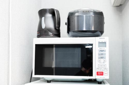 a microwave with a slow cooker on top of it at 鎌倉四丁目 in Tokyo